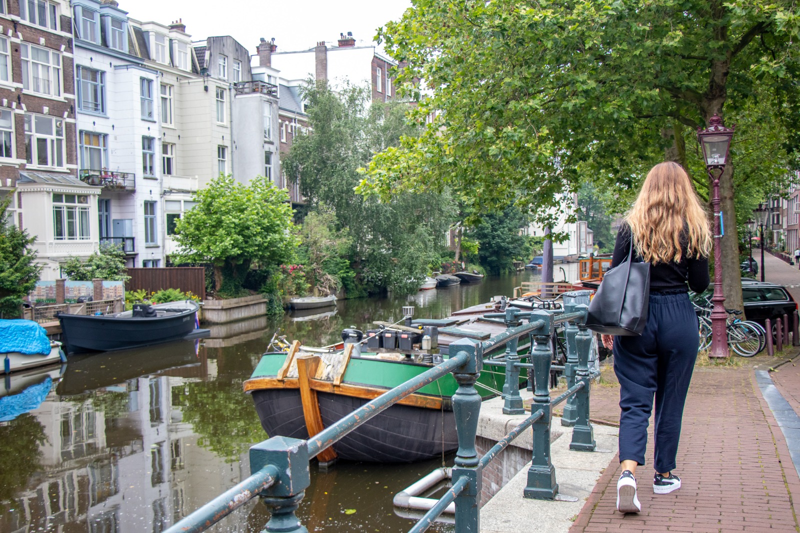 Person walking beside a canal in Amsterdam, Netherlands