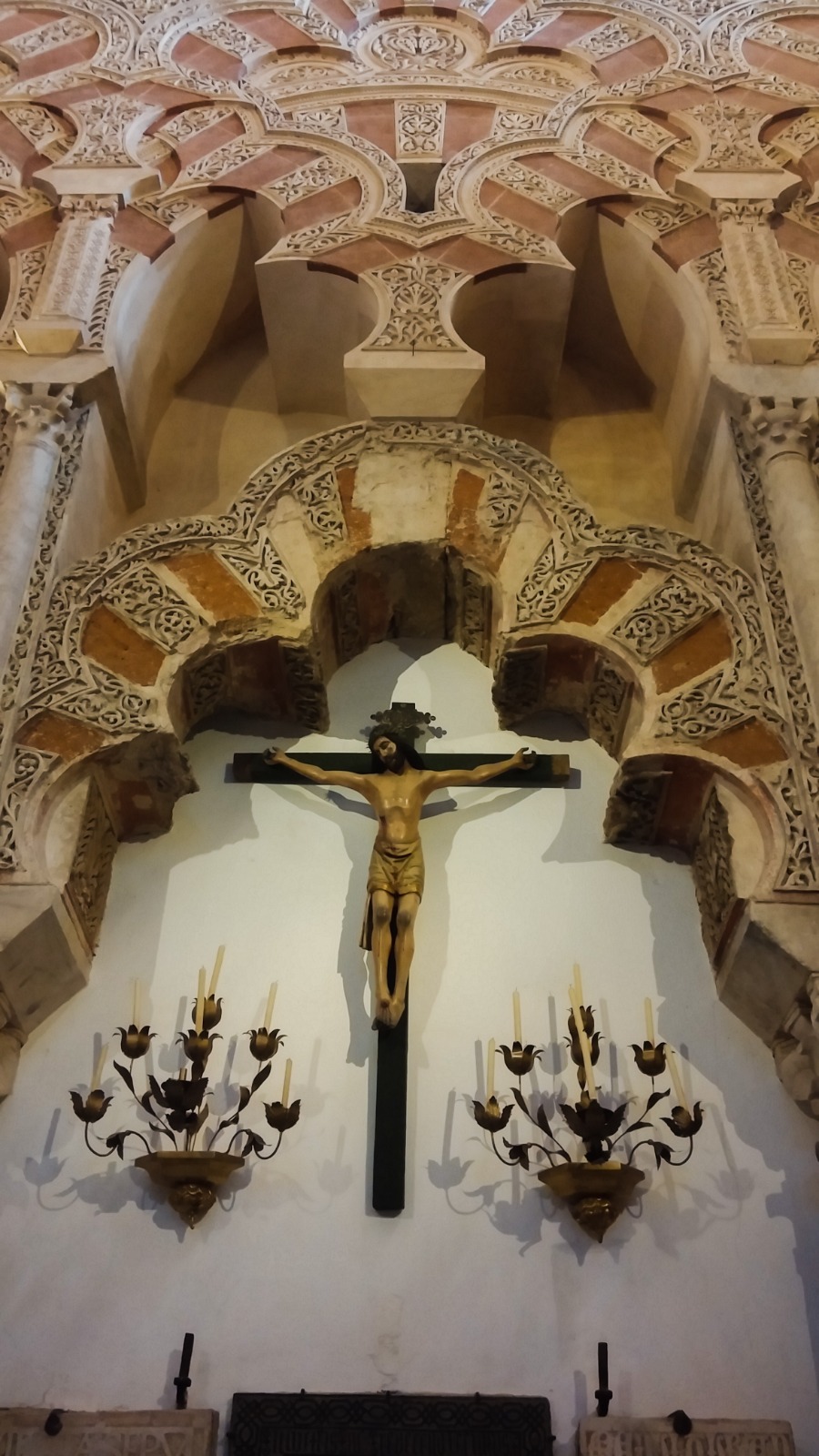 Christian crucifix framed by an Islamic arch inside the Mosque-Cathedral of Córdoba, Spain